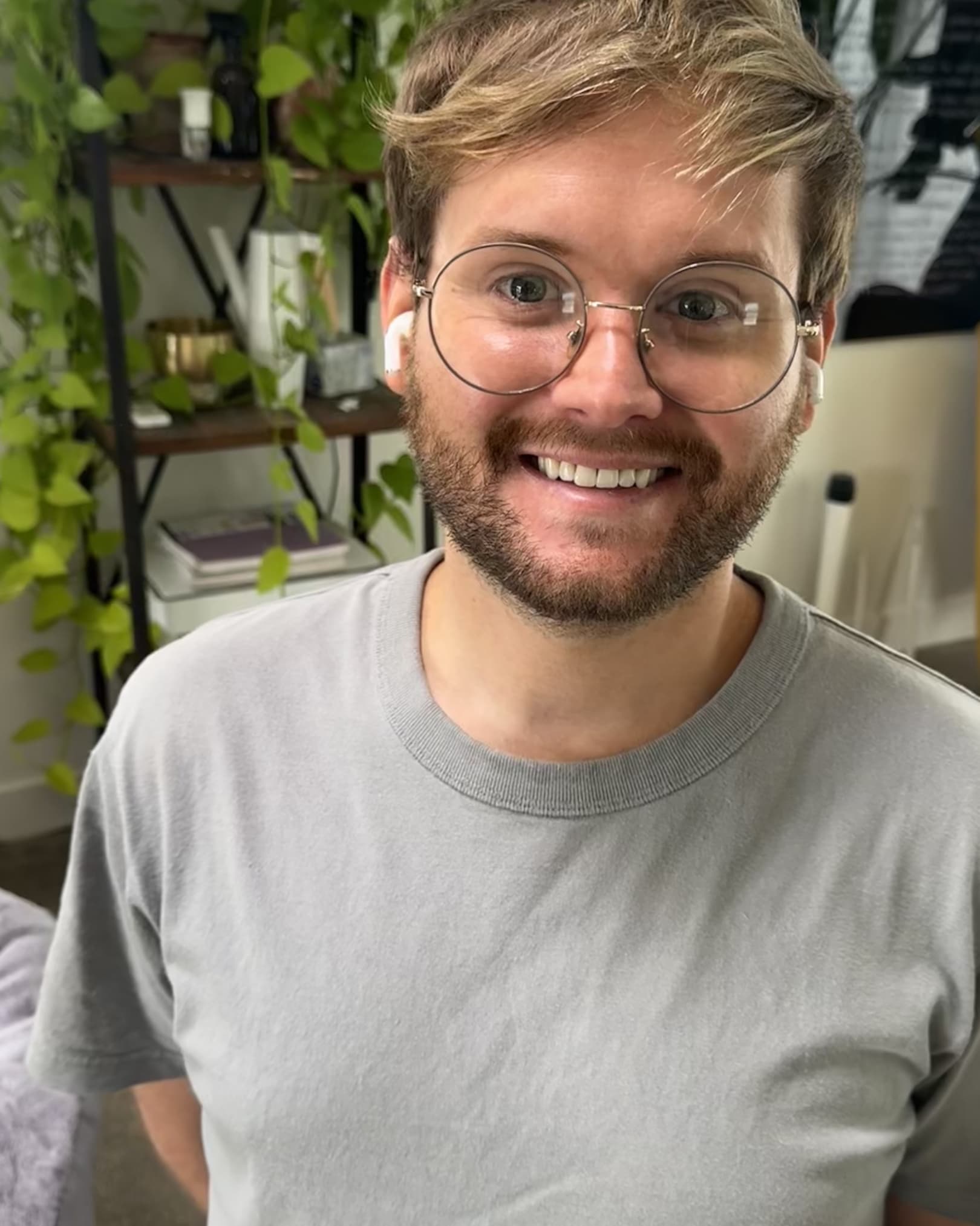 Portrait of Eric Moore smiling, wearing round glasses